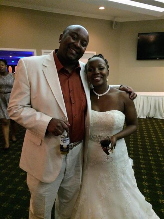 A joyful couple celebrates their wedding day surrounded by friends and family in a vibrant setting.