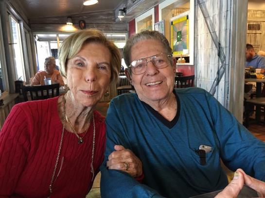 An older couple shares a joyful moment together while dining at a relaxed eatery.