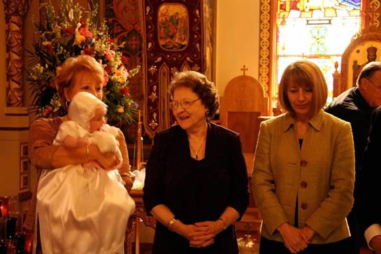 Women gather in a church, smiling and sharing a joyful moment during a family celebration.