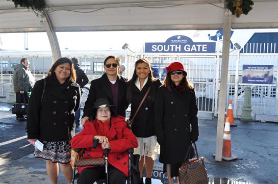 Group of five people, including a woman in a red coat, enjoying a sunny day at South Gate.