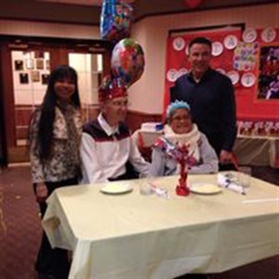 Four family members gather at a festive table, enjoying a joyful celebration together.