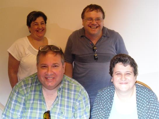 Four family members happily posing together, showing their close bond in a relaxed setting.