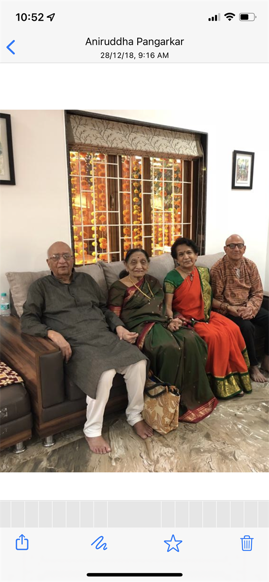 Elderly loved ones in traditional attire enjoy happy moments in a cozy home.