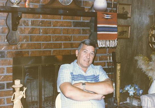 Man enjoys a moment of relaxation in a warm, rustic room decorated with traditional items.