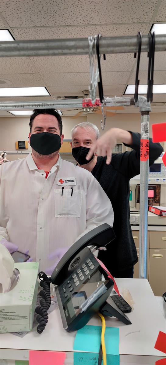 Two healthcare workers smile together, highlighting teamwork and camaraderie at a facility.