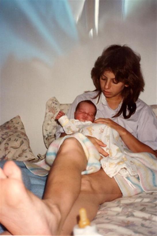 A mother lovingly cradles her newborn in a warm, serene moment.