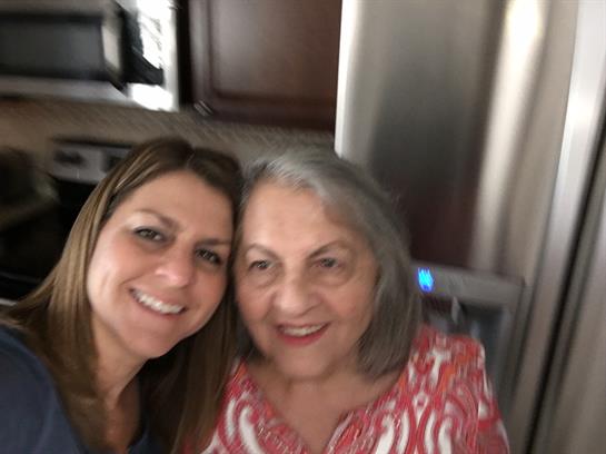 Two women enjoy a joyful moment together in a cozy kitchen, celebrating family time.