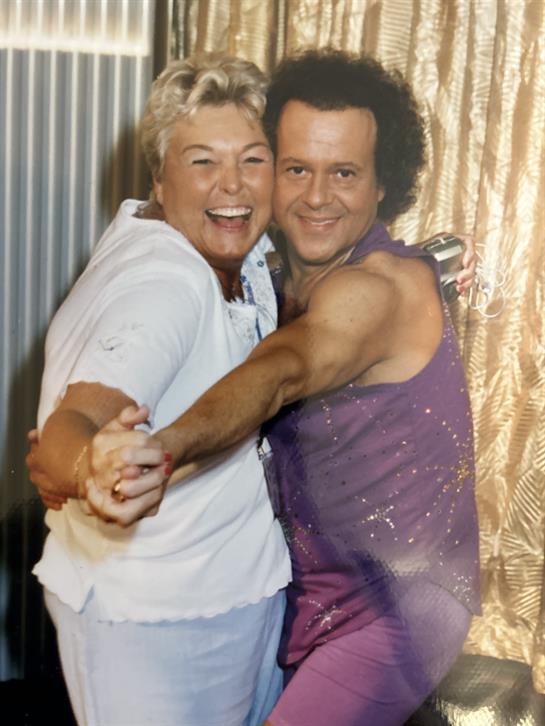 Two people share a joyful dance at a lively gathering, showcasing their happiness and connection.