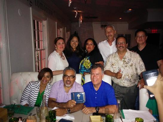 Friends gather around a table sharing laughter and good food in an inviting restaurant ambiance.