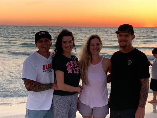 Friends gather on the beach during sunset, capturing a moment of joy and togetherness.