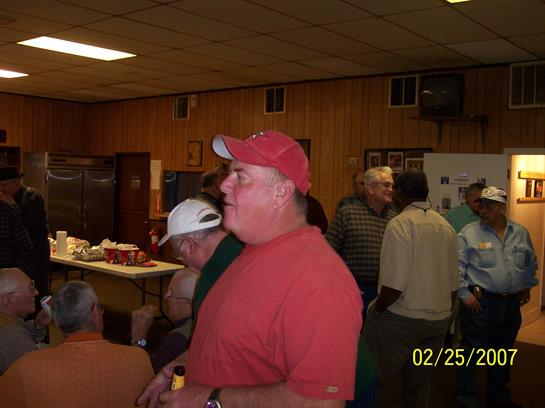 Participants interact and socialize at a community event with food and drinks served.