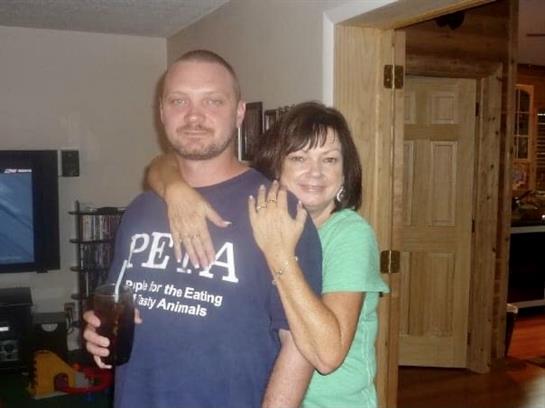 A couple poses happily together in their cozy living room, sharing a joyful moment.