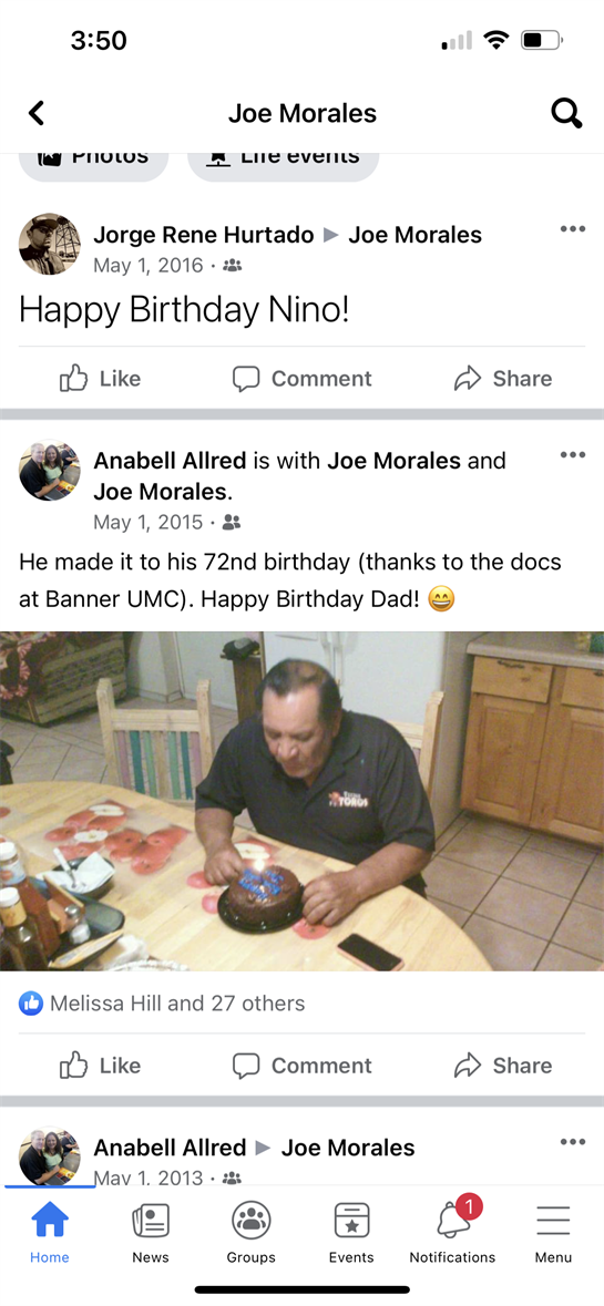 Family gathers to celebrate a 72nd birthday with cake at the kitchen table.