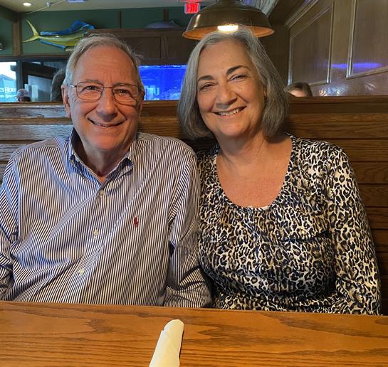 A couple shares a joyful moment in a warm restaurant, smiling and having a great time together.