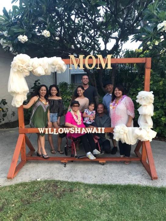 Family gathers outside to celebrate mom with festive decor and smiles.
