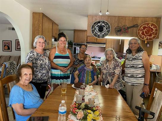 Friends come together in a warm kitchen to celebrate a special occasion with food and laughter.