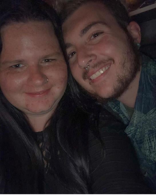 Two friends smile happily together, enjoying a fun evening filled with laughter and camaraderie.