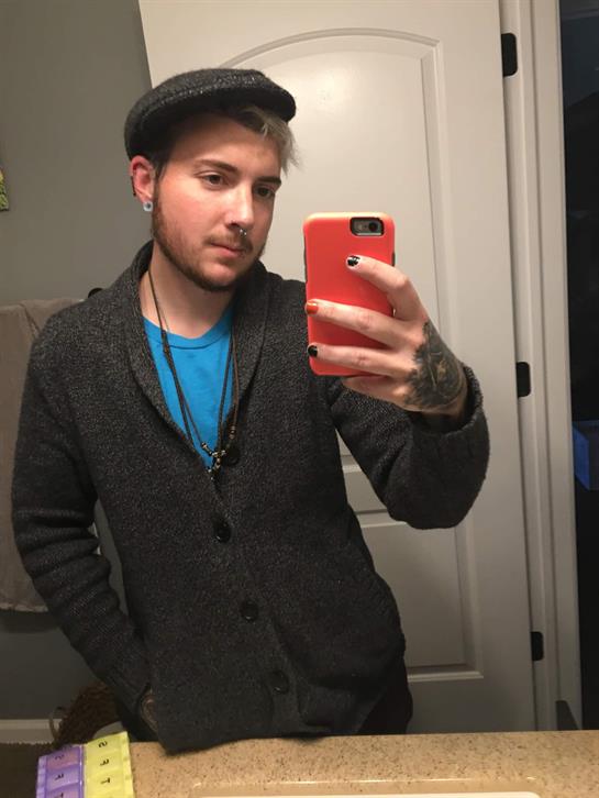 Individual poses for a selfie in a bathroom, showcasing a comfortable outfit and a relaxed vibe.