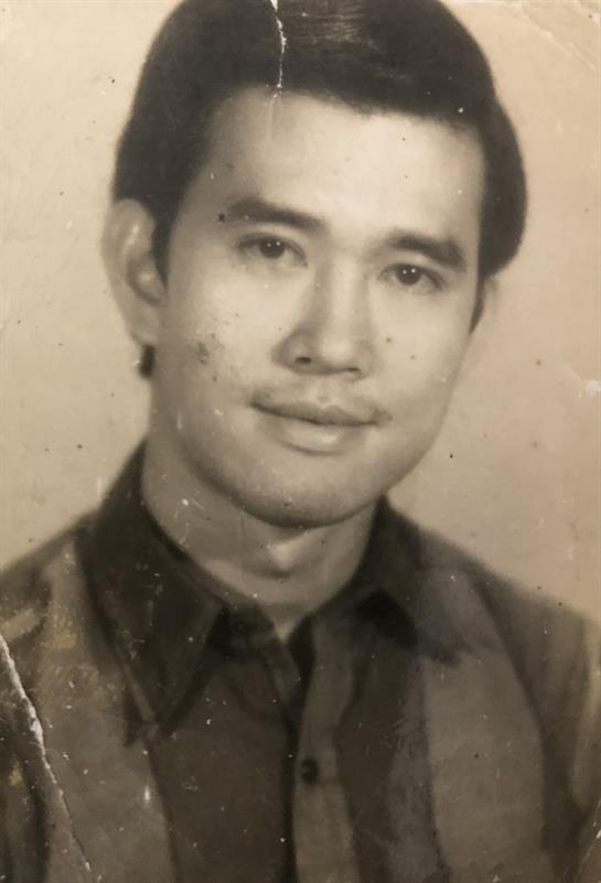 A man with a slight smile poses in formal wear, capturing an authentic vintage style from the past.