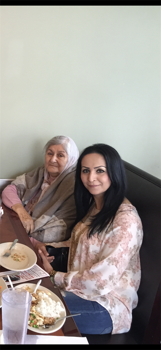 Two women share a joyful moment together while enjoying lunch at a restaurant during the afternoon.