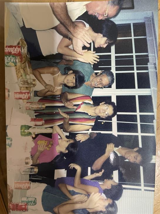 Family members are celebrating together, sharing laughter and joy during a cozy evening indoors.