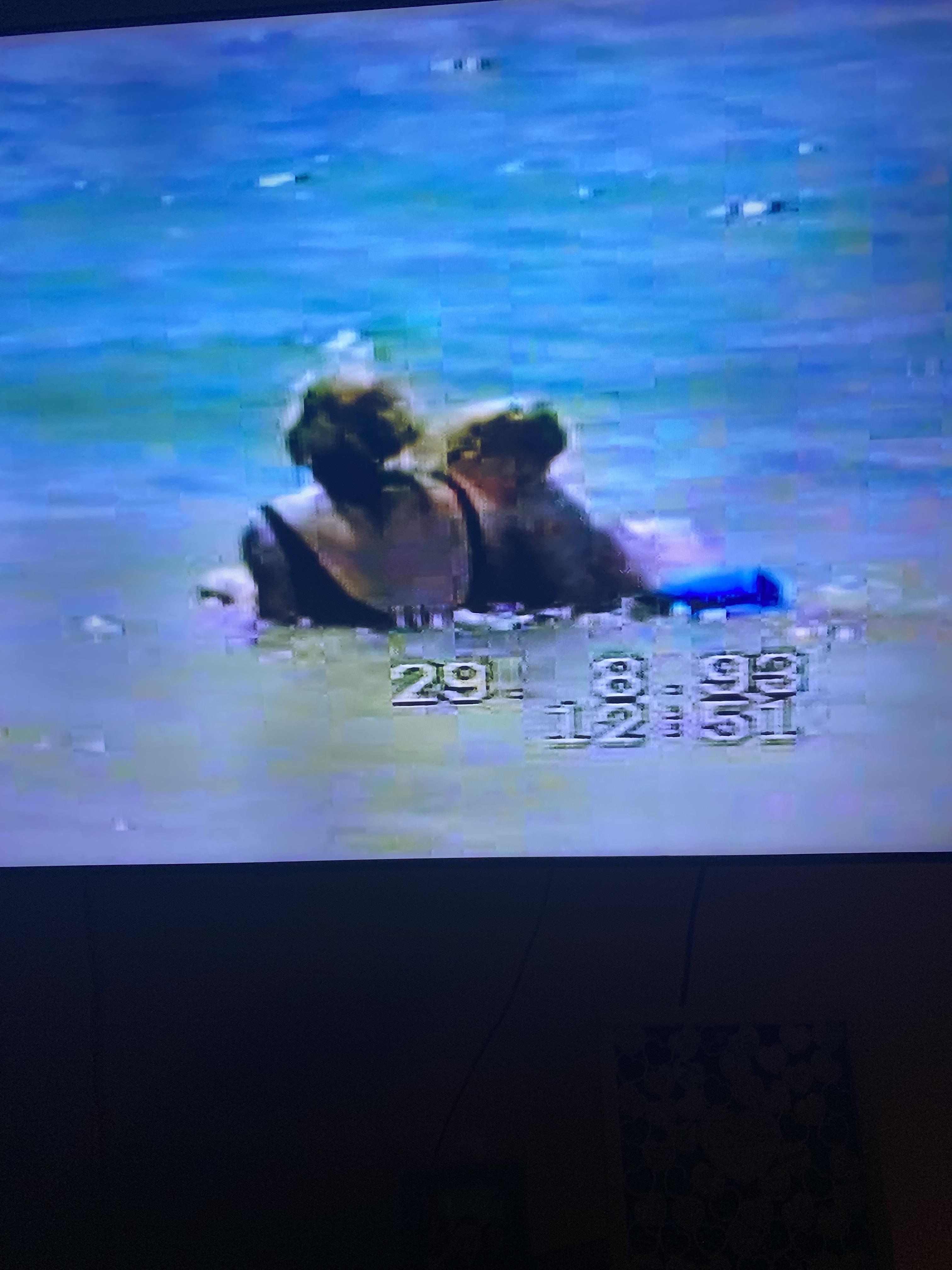 A couple swims together in the ocean, enjoying the warm summer water on a bright day.