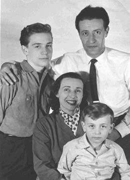 Four family members smile together indoors, highlighting their close bond.
