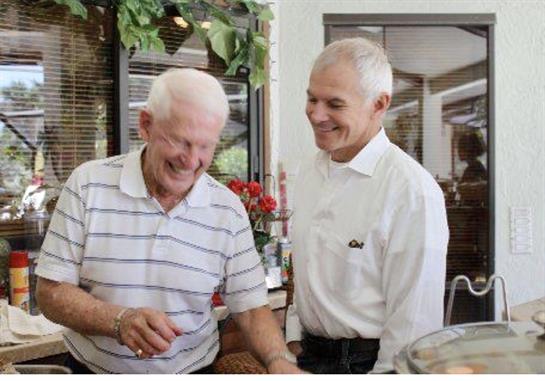 Two men enjoy a joyful moment together while chatting and laughing in a cafe.