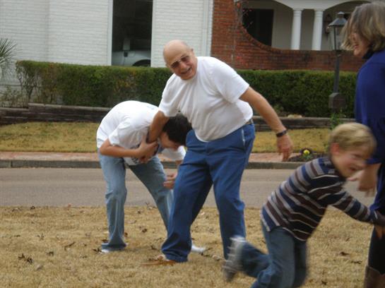 Children playfully engage with an older man, creating joyful memories in the yard.
