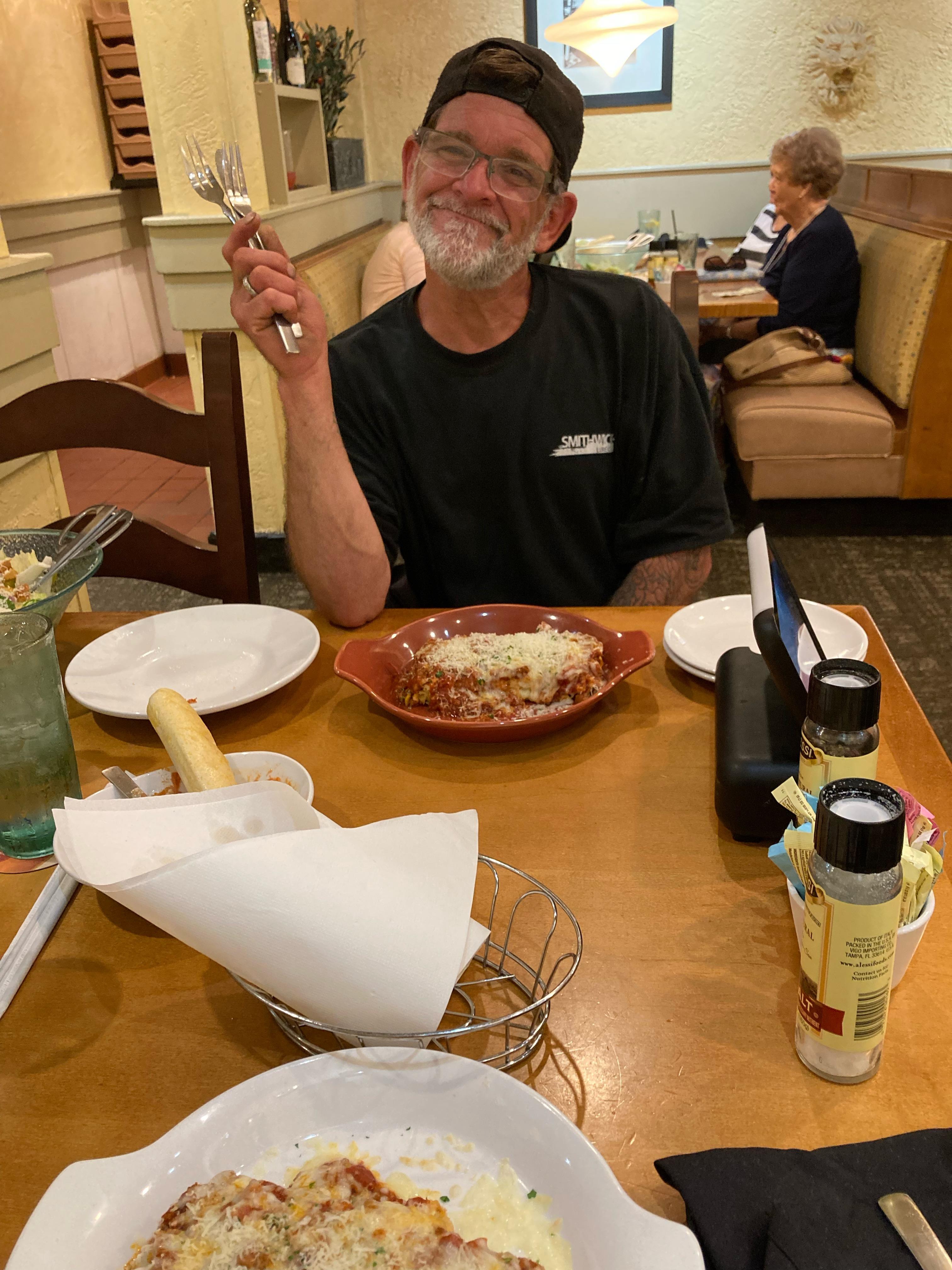 Friends savor a delicious meal together at a warm, inviting restaurant while smiling.