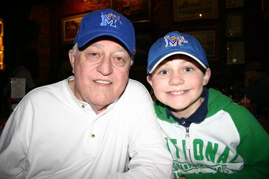 A smiling grandfather and grandson share a warm moment, highlighting their strong bond.