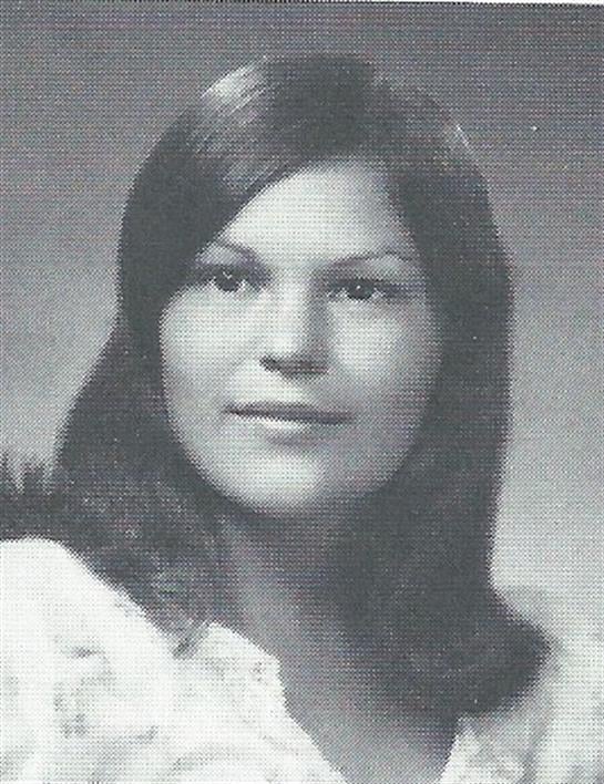 A young woman poses elegantly with long hair and a gentle expression captured during the 1970s.