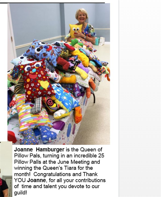 Joanne Hamburger smiles while standing near a table stacked with colorful handmade pillows.