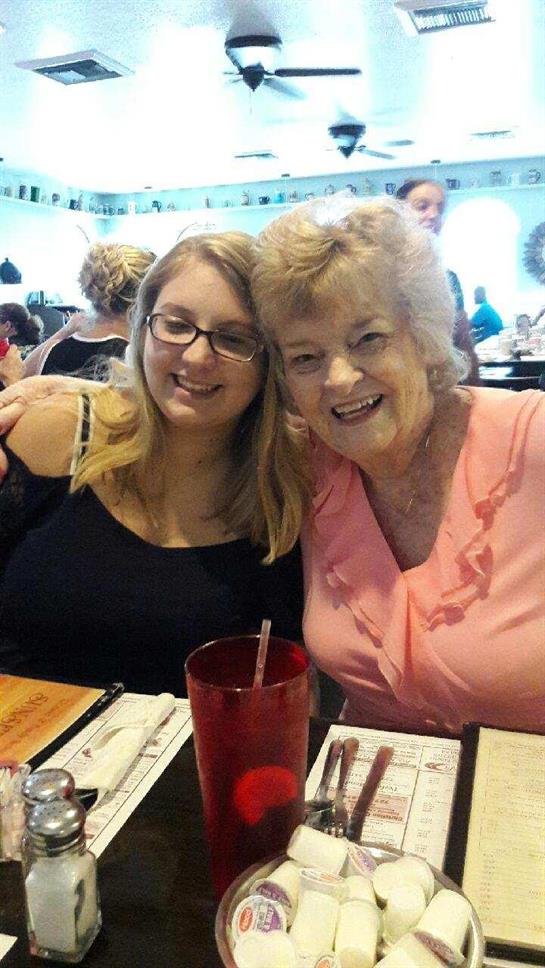 Two women enjoy a cheerful moment together at a lively restaurant during lunchtime.