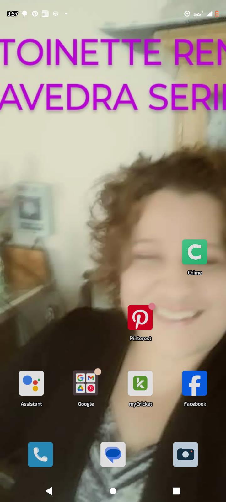 A cheerful woman with curly hair is smiling at home, radiating joy and positivity in a cozy setting.