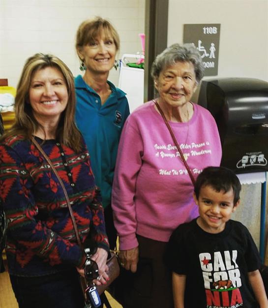 Group of four individuals posing for a picture at a community center, enjoying their time together.