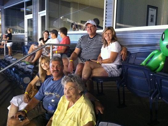 Groups of people enjoy time together at a local stadium, sharing laughter and conversation.