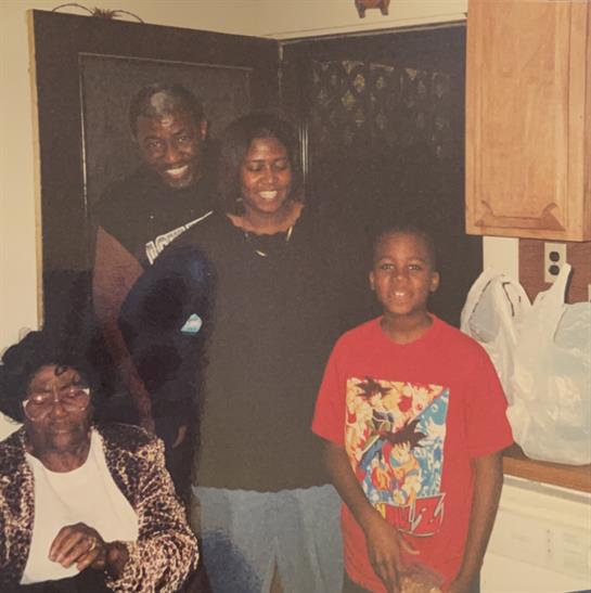 A joyful family poses together in a warm kitchen filled with laughter and companionship.