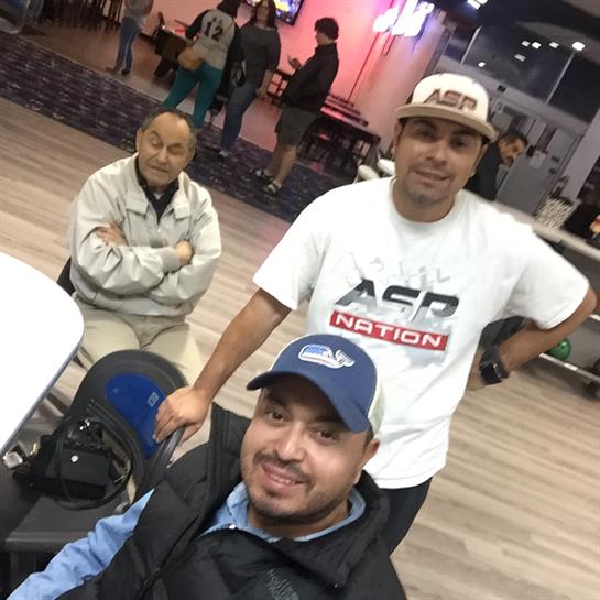 Group of friends laughing and socializing at a lively bowling venue, enjoying their time together.