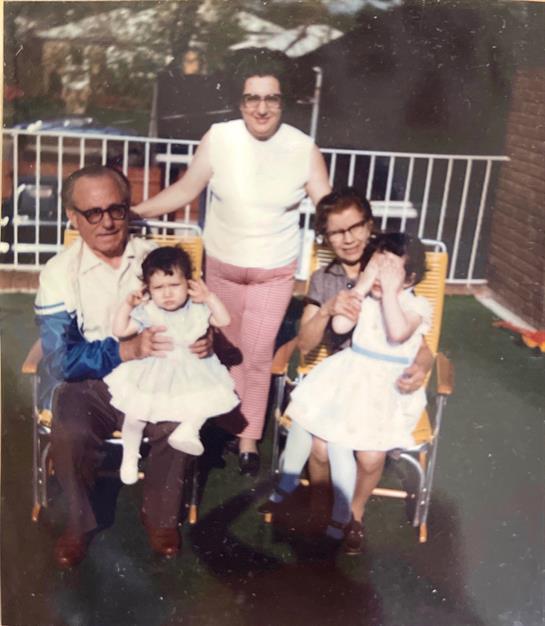 Grandparents and grandchildren relax in the backyard, making memories on a sunny day.