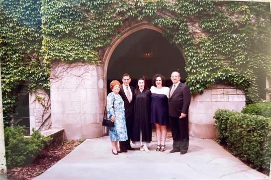A family gathers at an elegant entrance, celebrating joyfully in stylish attire.