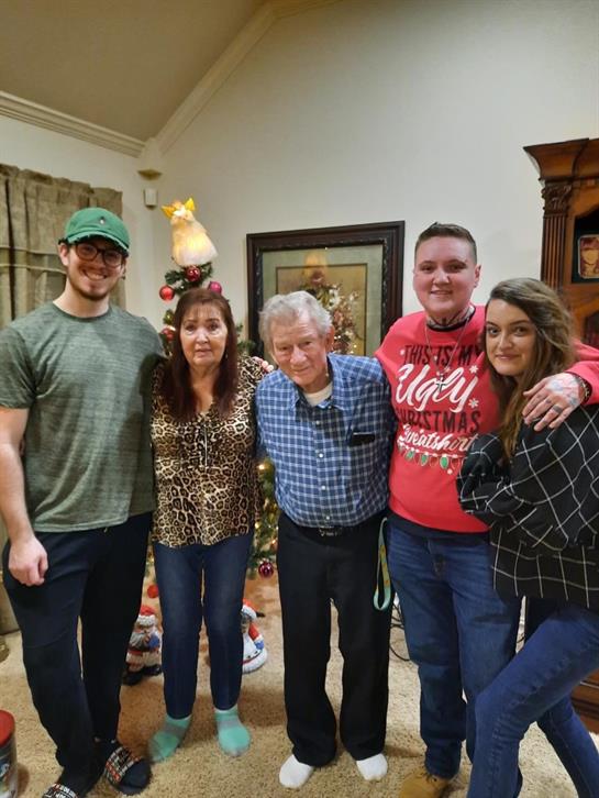 Guests celebrate together in a warmly decorated living room, showcasing holiday spirit and joy.