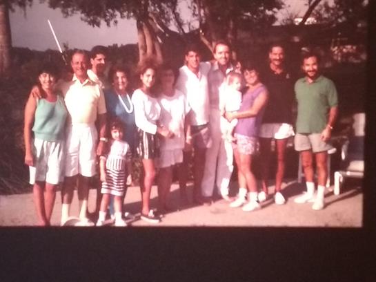 Group of people enjoying a summer day together in a park setting, smiling and posing for the camera.