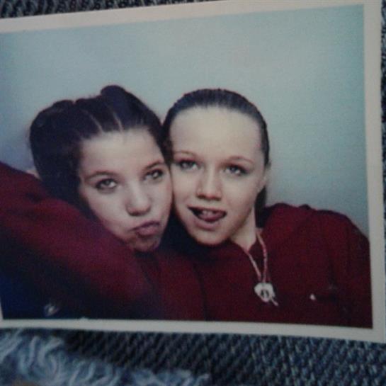 Two young women share playful poses and smiles while enjoying each other's company.