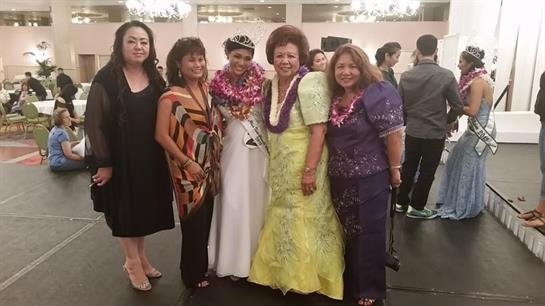 Group of women in traditional attire celebrating with a beauty queen at a cultural event.