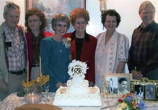 Family and friends gather to celebrate a special 50th anniversary with a beautiful cake.