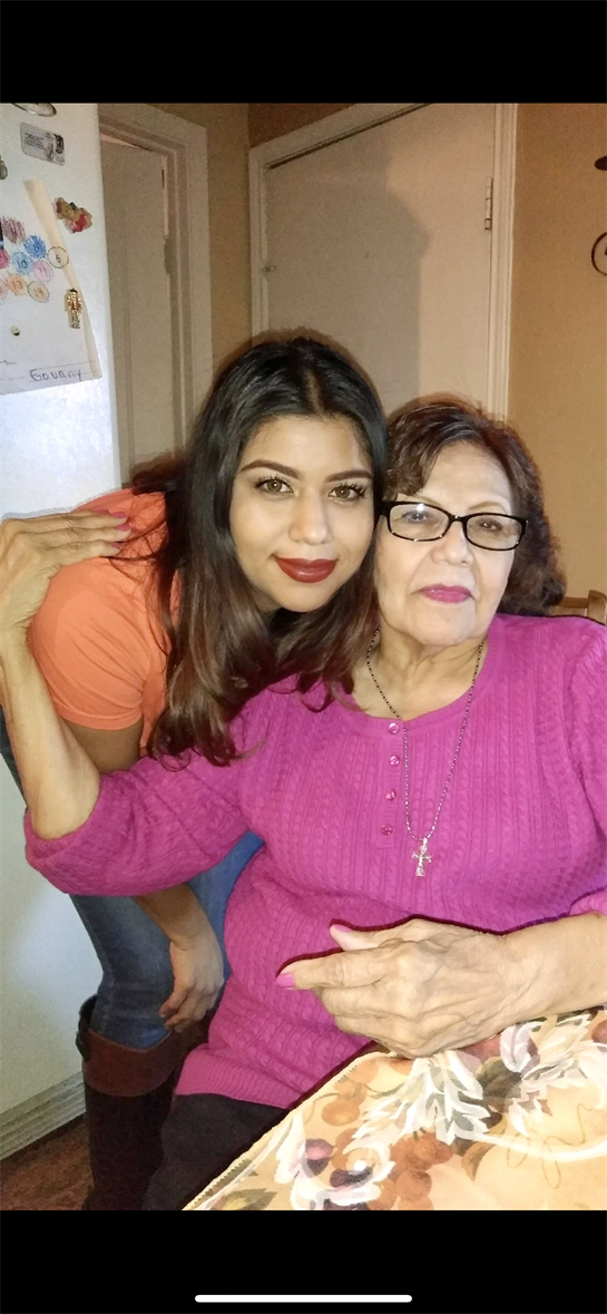 A woman and her grandmother share a warm, joyful moment in a cozy kitchen.