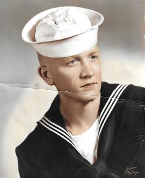 A young sailor in uniform smiles while gazing off to the side in this vintage portrait.