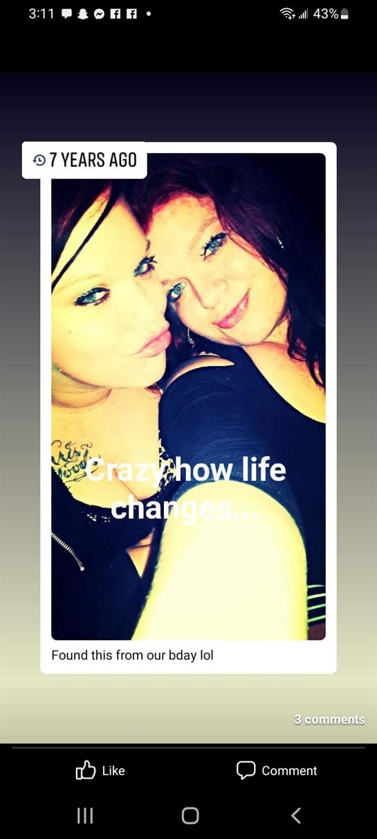 Two friends smile and pose closely together, showcasing their happiness in a friendly atmosphere.