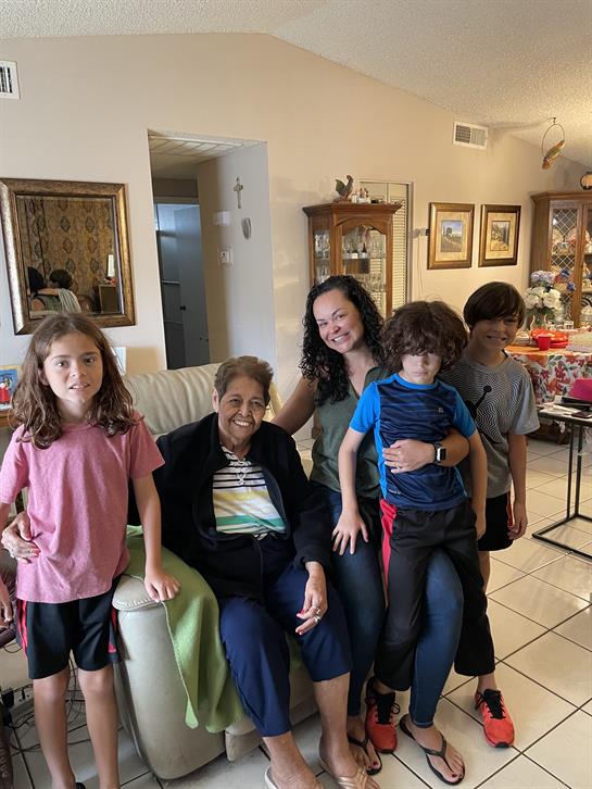 A grandmother enjoys time with her grandchildren in a warm, welcoming living room.